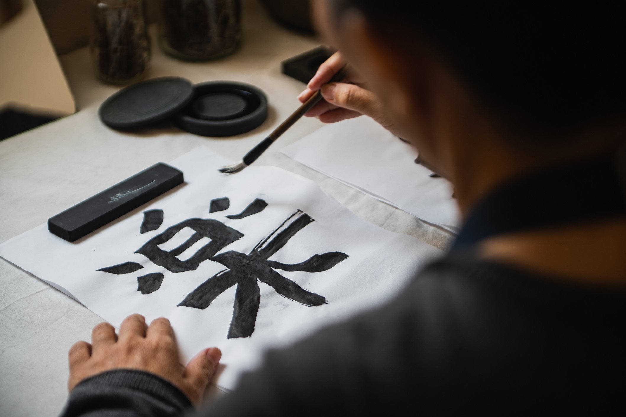 Person Writing Japanese Calligraphy